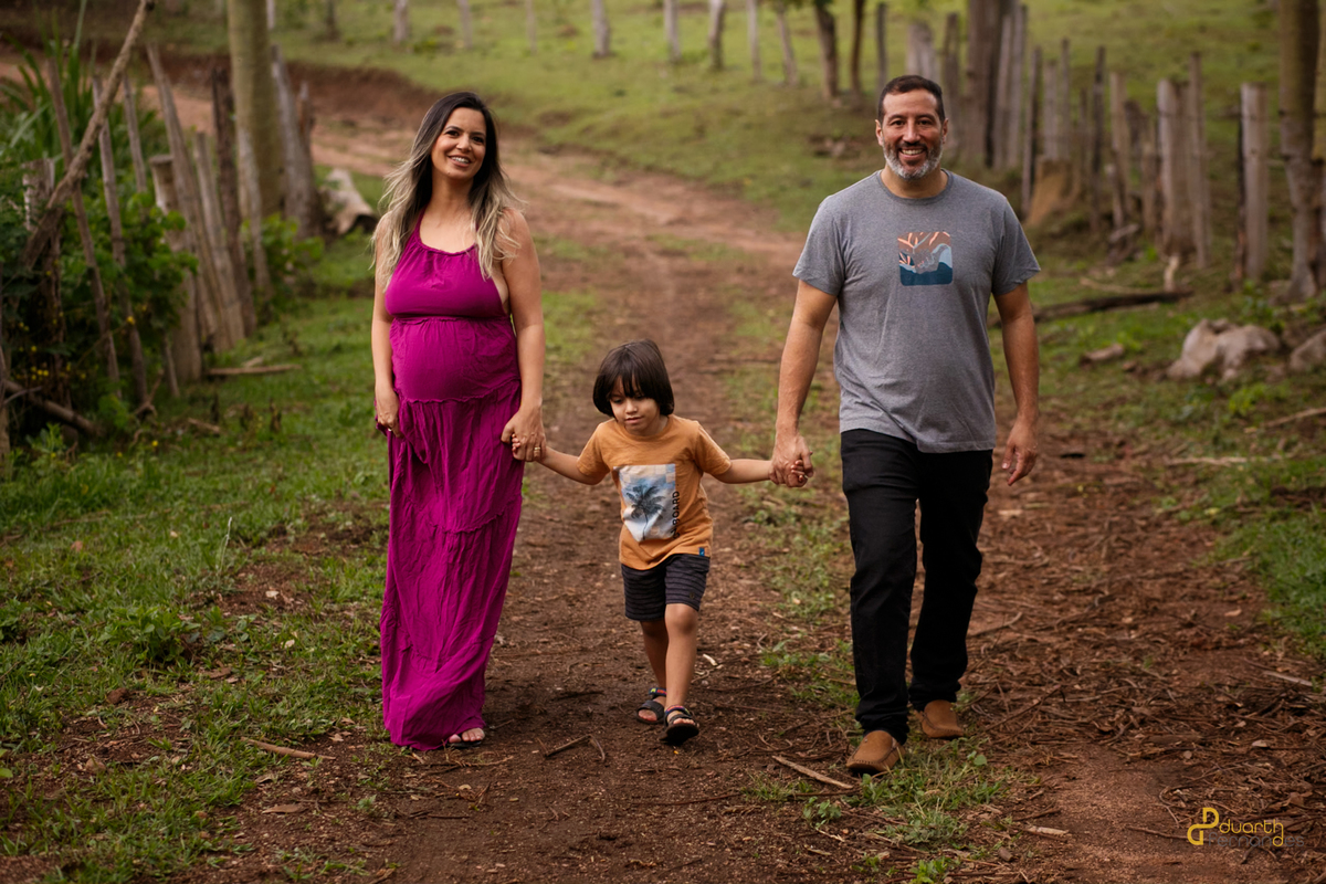 Foto de casal com o filho andando na cidade de itamarandiba mg num ensaio fotografico