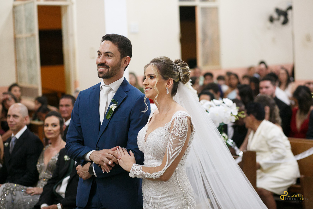 Noivo segurando carinhosamente a mão da noiva.