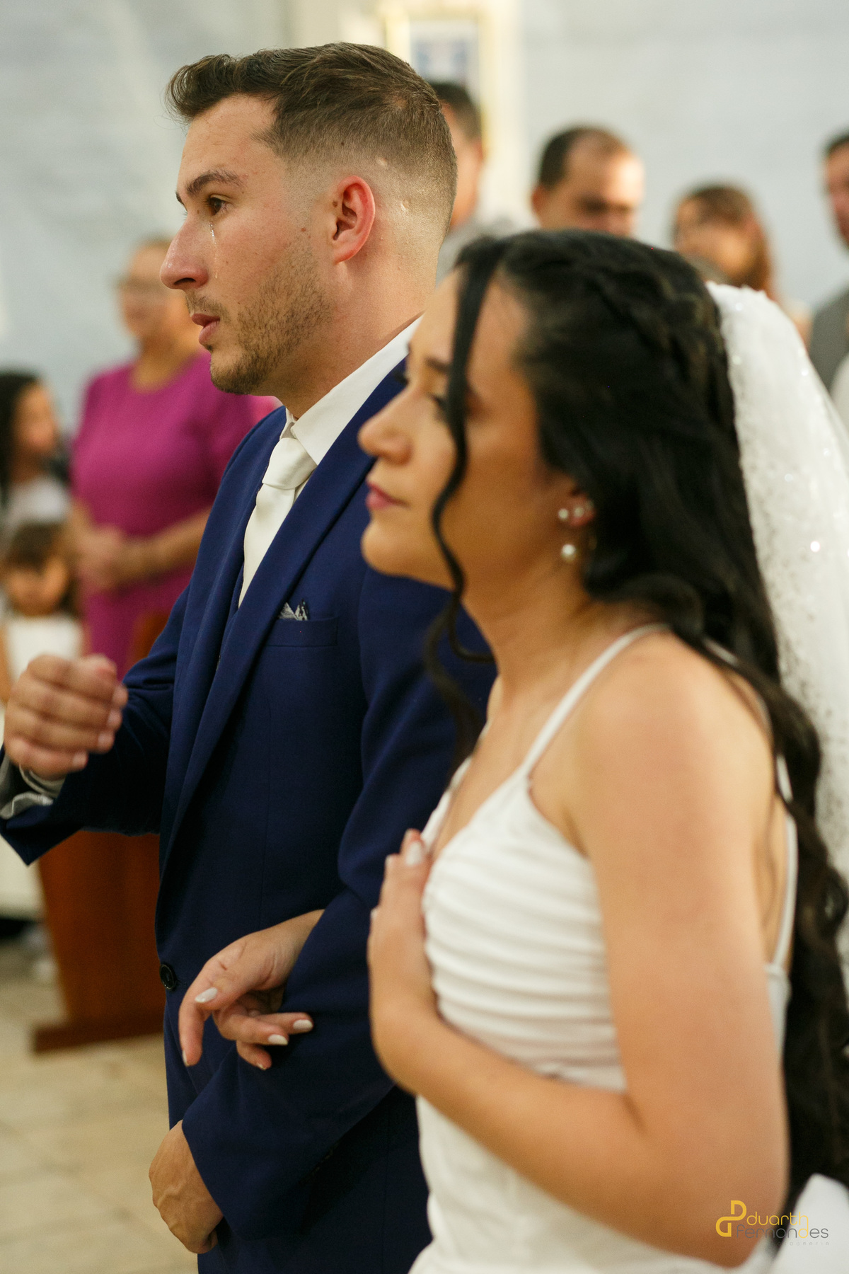Noiva Mariana emocionada e noivo Lucas sorrindo no altar, cerimônia de casamento em Turmalina, MG.