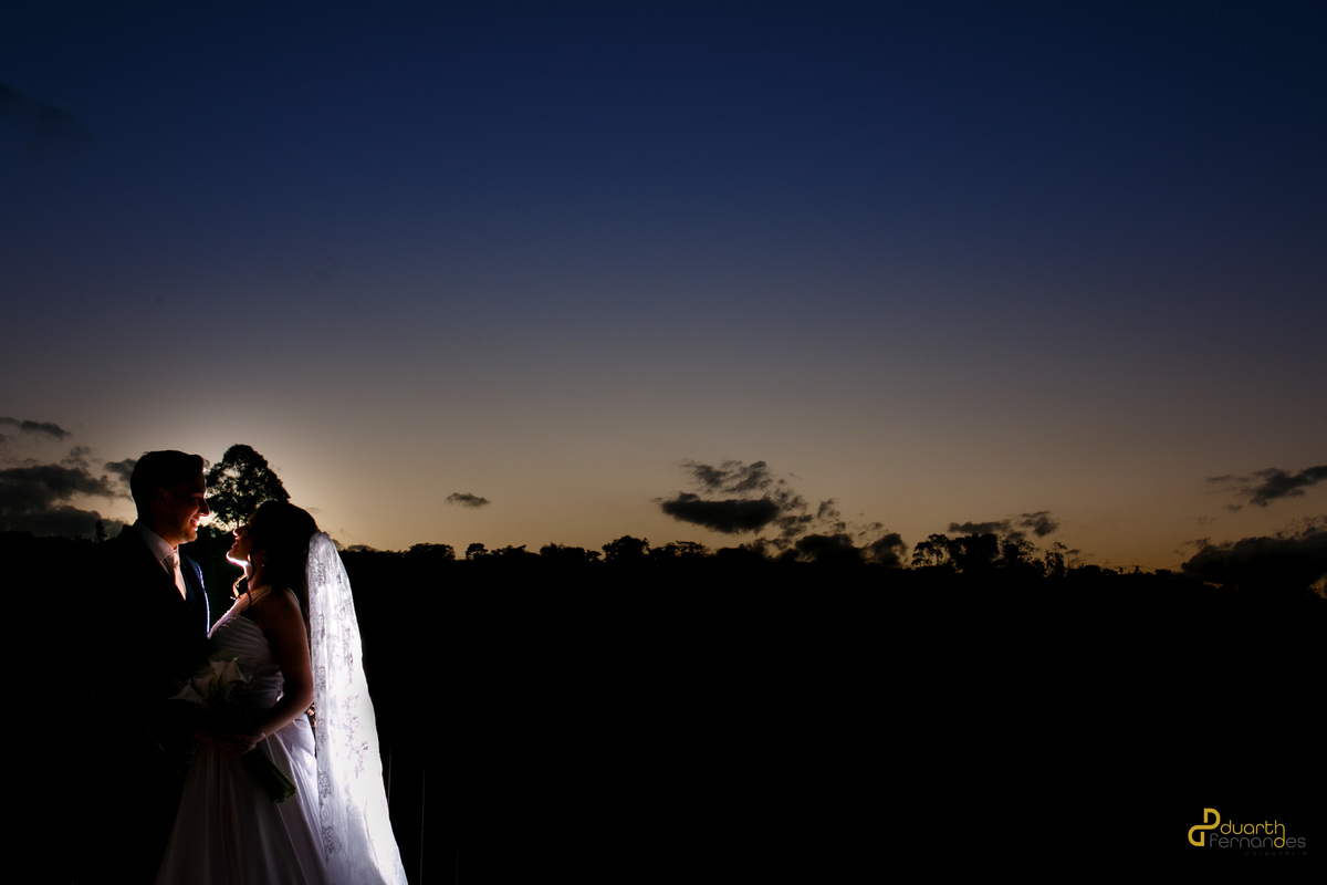 Silhueta dos noivos Mariana e Lucas ao pôr do sol em Turmalina, MG, foto romântica de casamento.