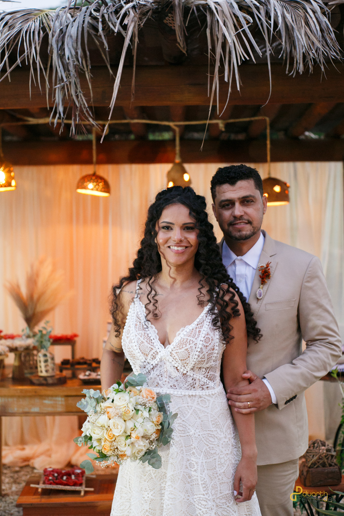 Os noivos Leandro e Jacyara saindo da cerimônia, rodeados por bolhas de sabão e com sorrisos de felicidade, enquanto amigos e familiares comemoram o grande dia. Momento alegre e espontâneo.