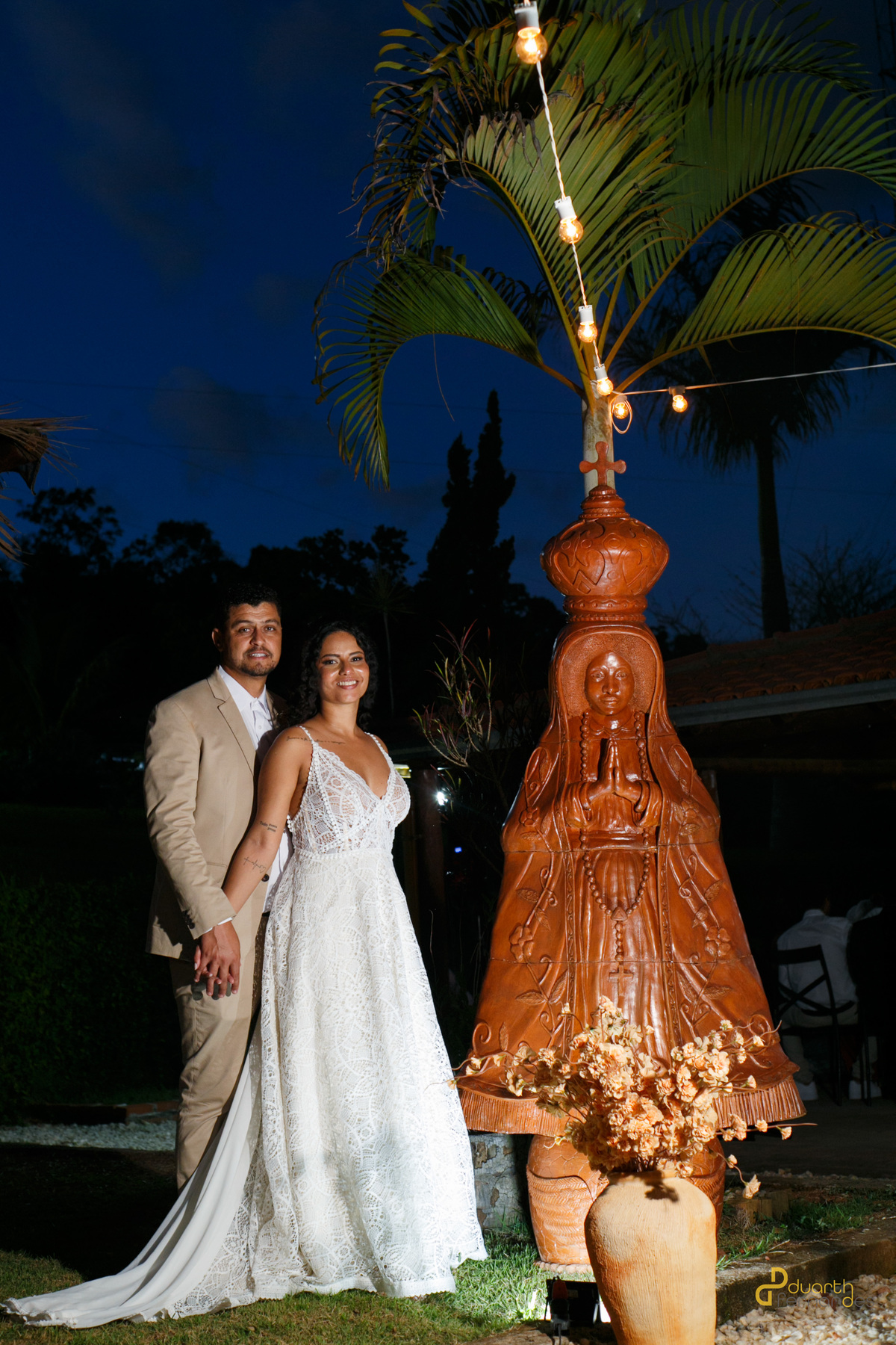 Detalhe do vestido da noiva Jacyara, mostrando as costas elegantes e a tatuagem delicada, capturado de forma estilosa. A luz suave revela o design do vestido e a beleza natural da noiva.