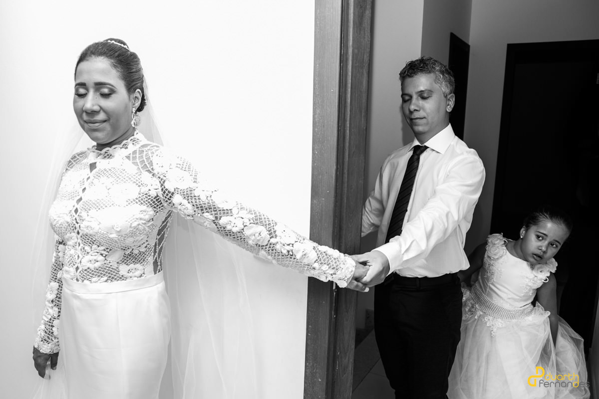 Noivo segurando mão da noiva e filha olhando