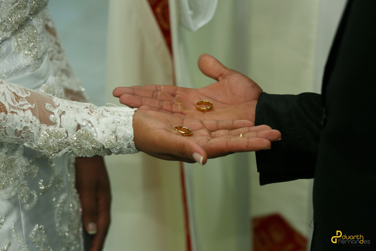 Noivos segurando as alianças