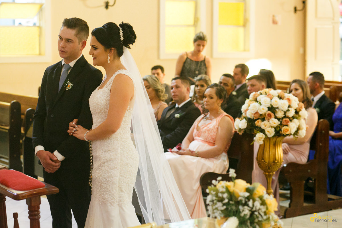 Noivos olhando para o altar na igreja de itamarandiba mg