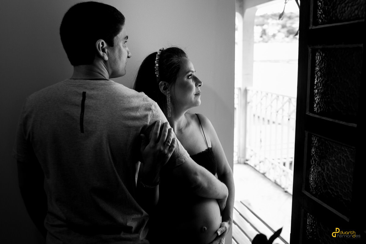 Casal à espera do filho, olhando pela janela