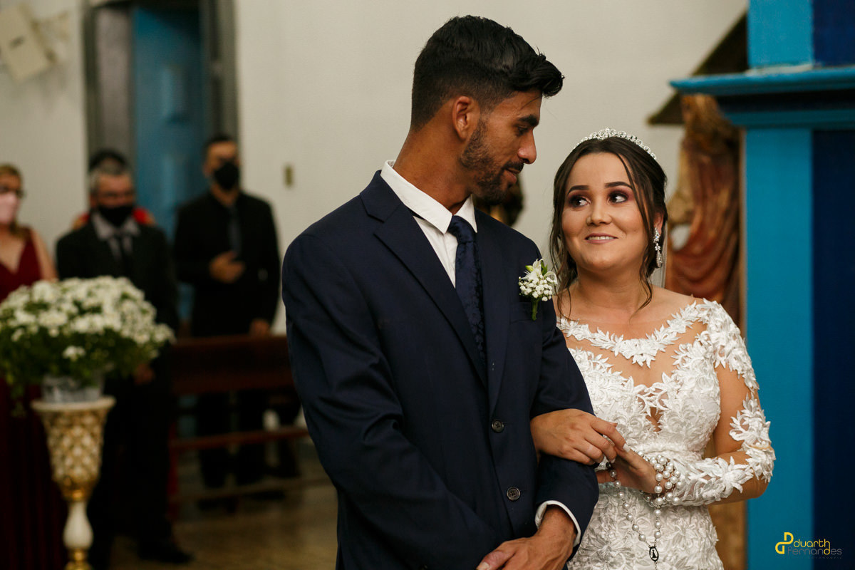 Foto de noivos no altar com a noiva olhando para o noivo