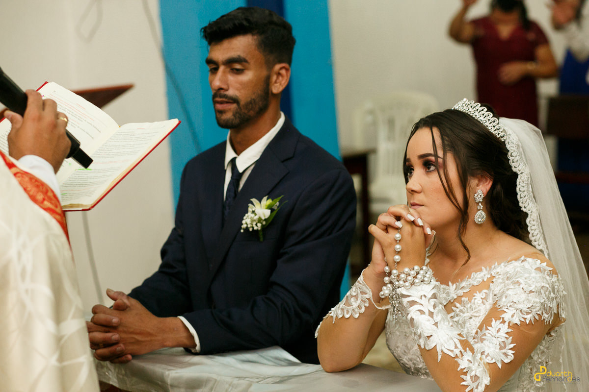 Noivos de frente ao padre no casamento na cidade de itamarandiba