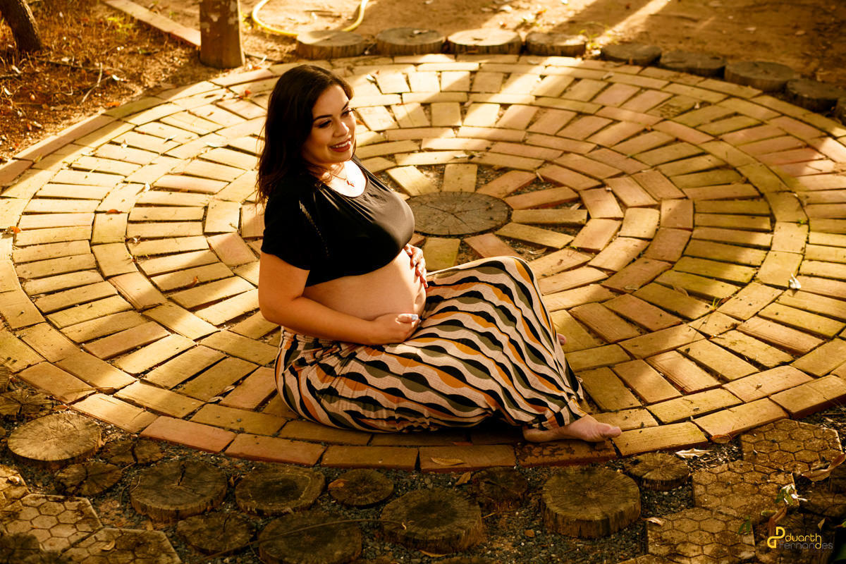 gestante deitada olhando para frente em moldura circular em turmalina mg