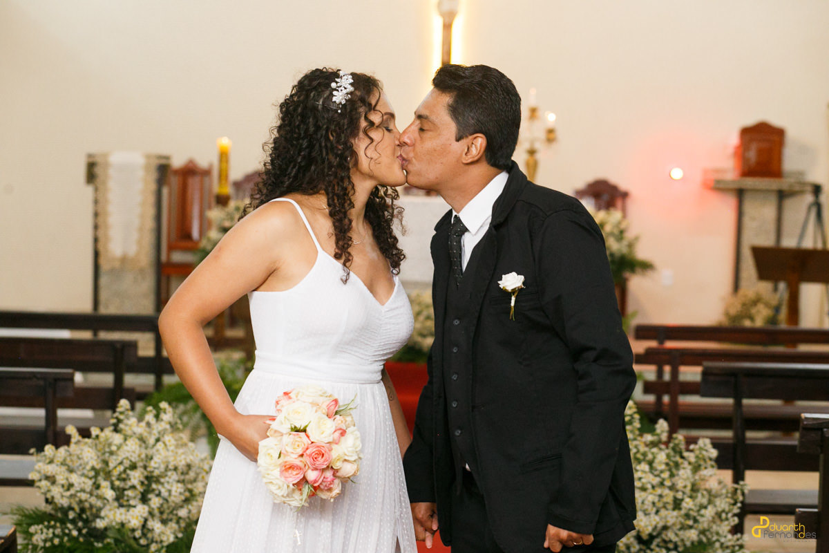 Noivos se beijando na saída da igreja em Acauã 