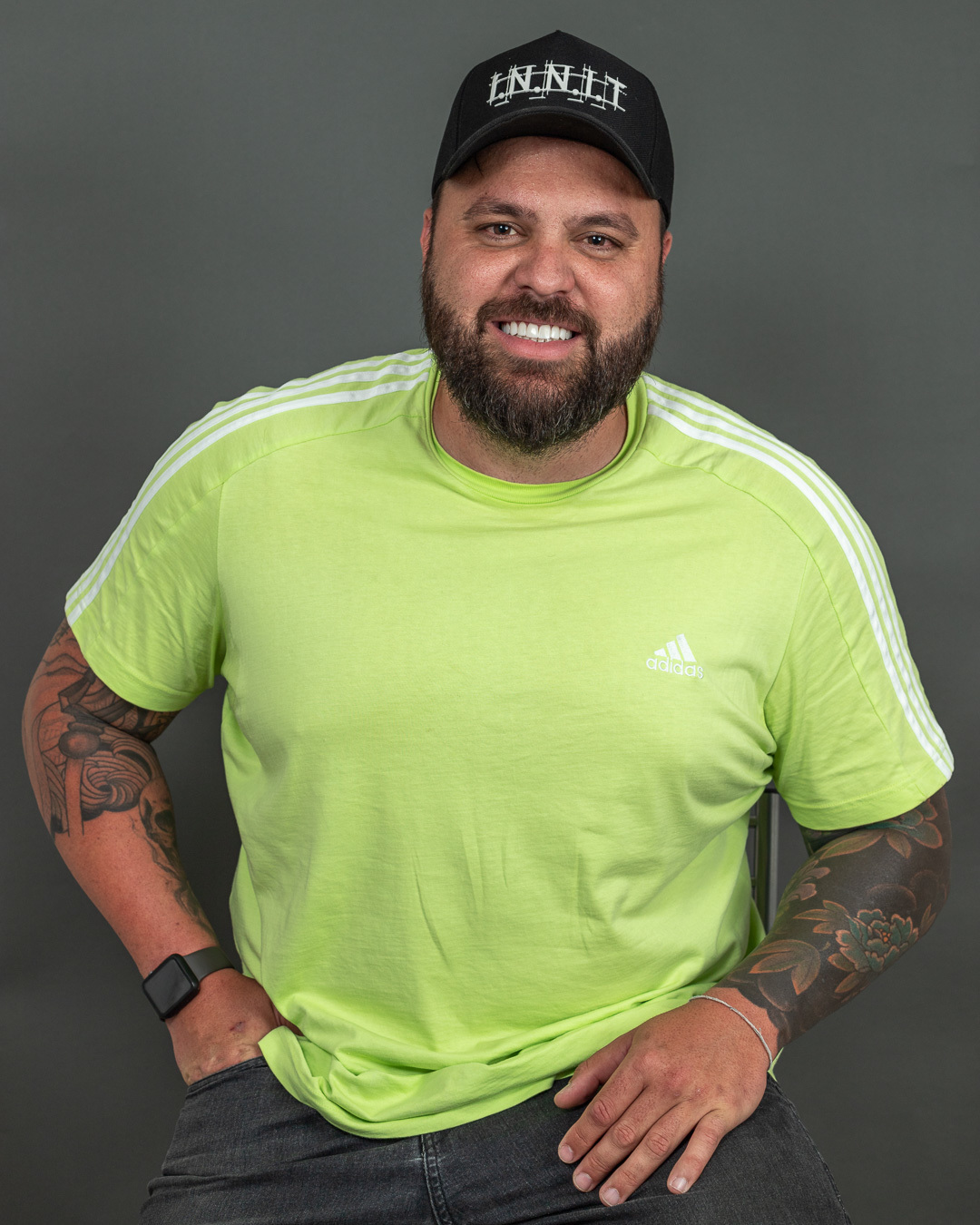 Retrato profissional de modelo masculino sentado sorrindo.