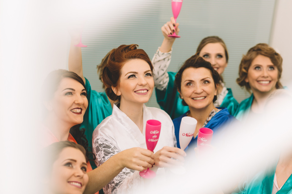 Noiva e madrinhas fazendo um brinde felizes