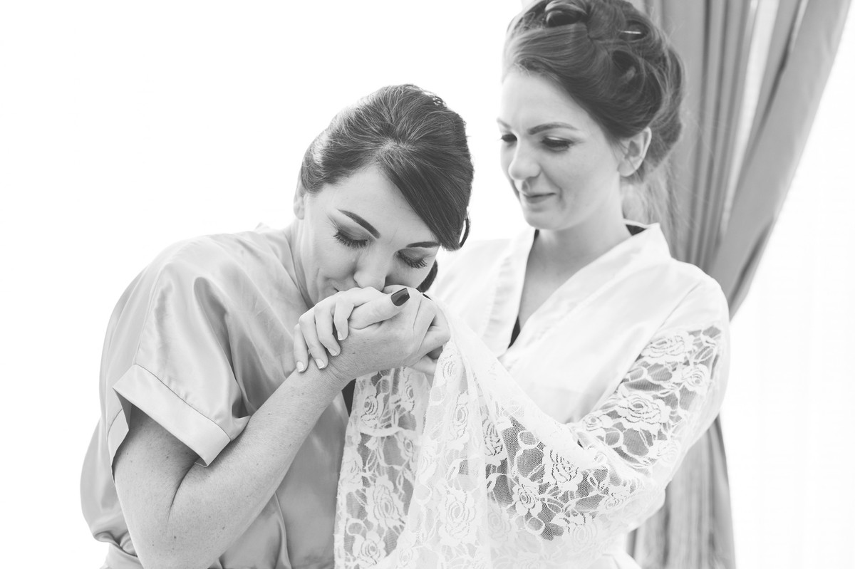 Mãe beijando a mão da noiva