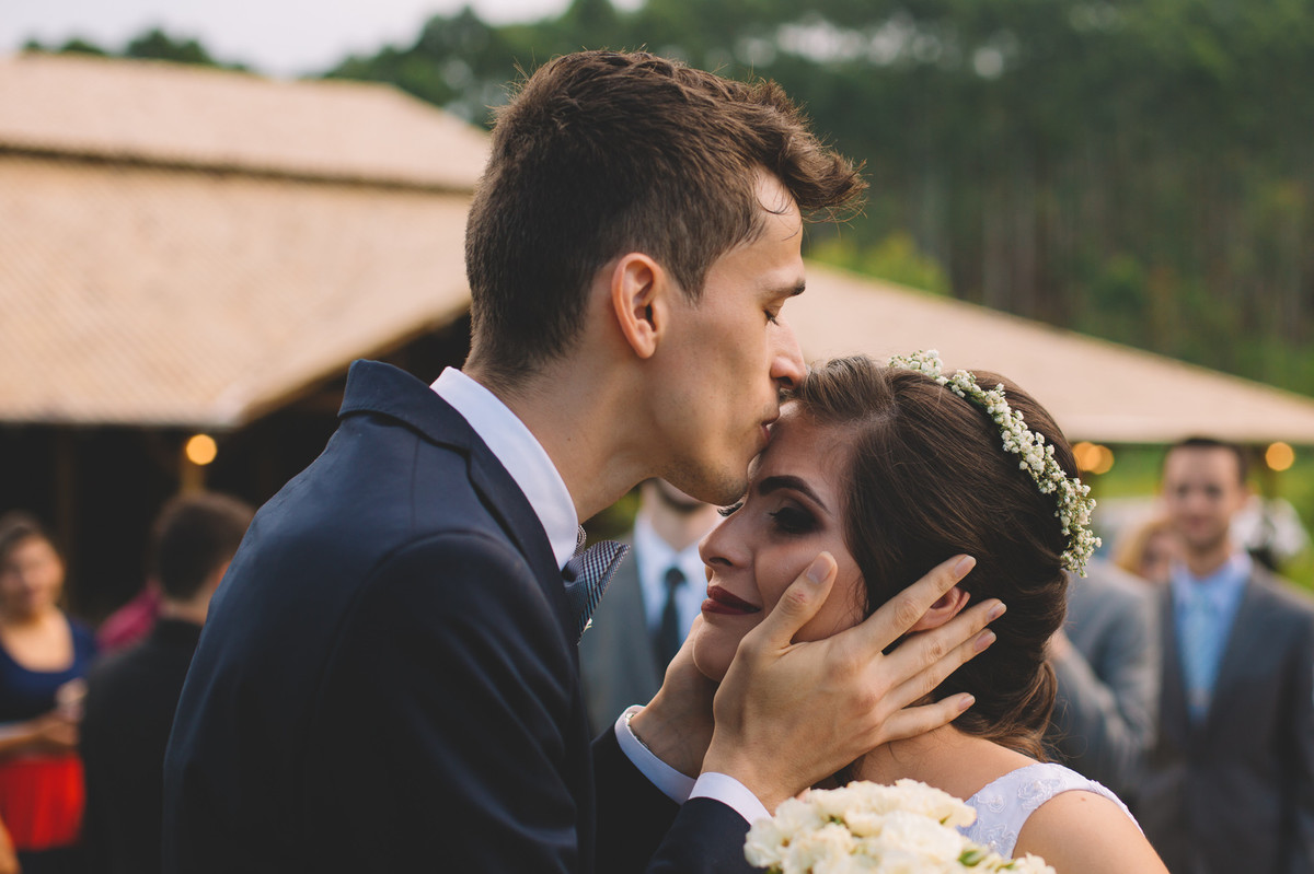Noivo beijando a testa da noiva