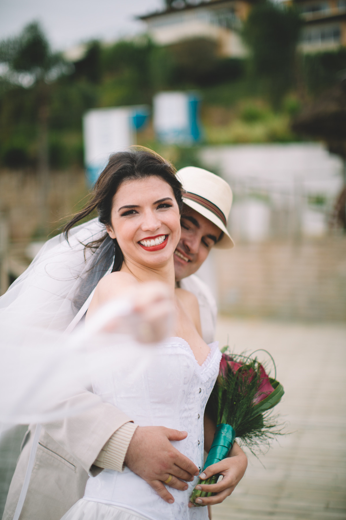 Noiva com segurando véu e Bouquet