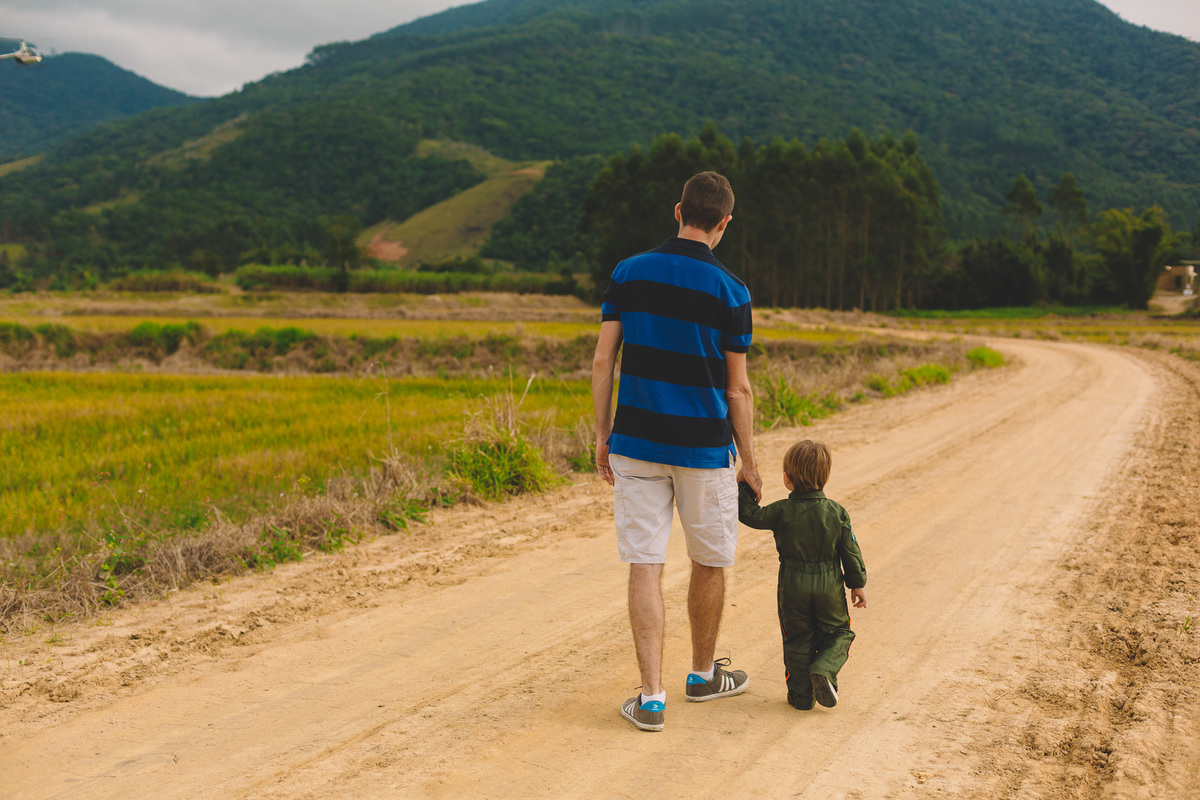 pai e filho caminhando de mãos dadas