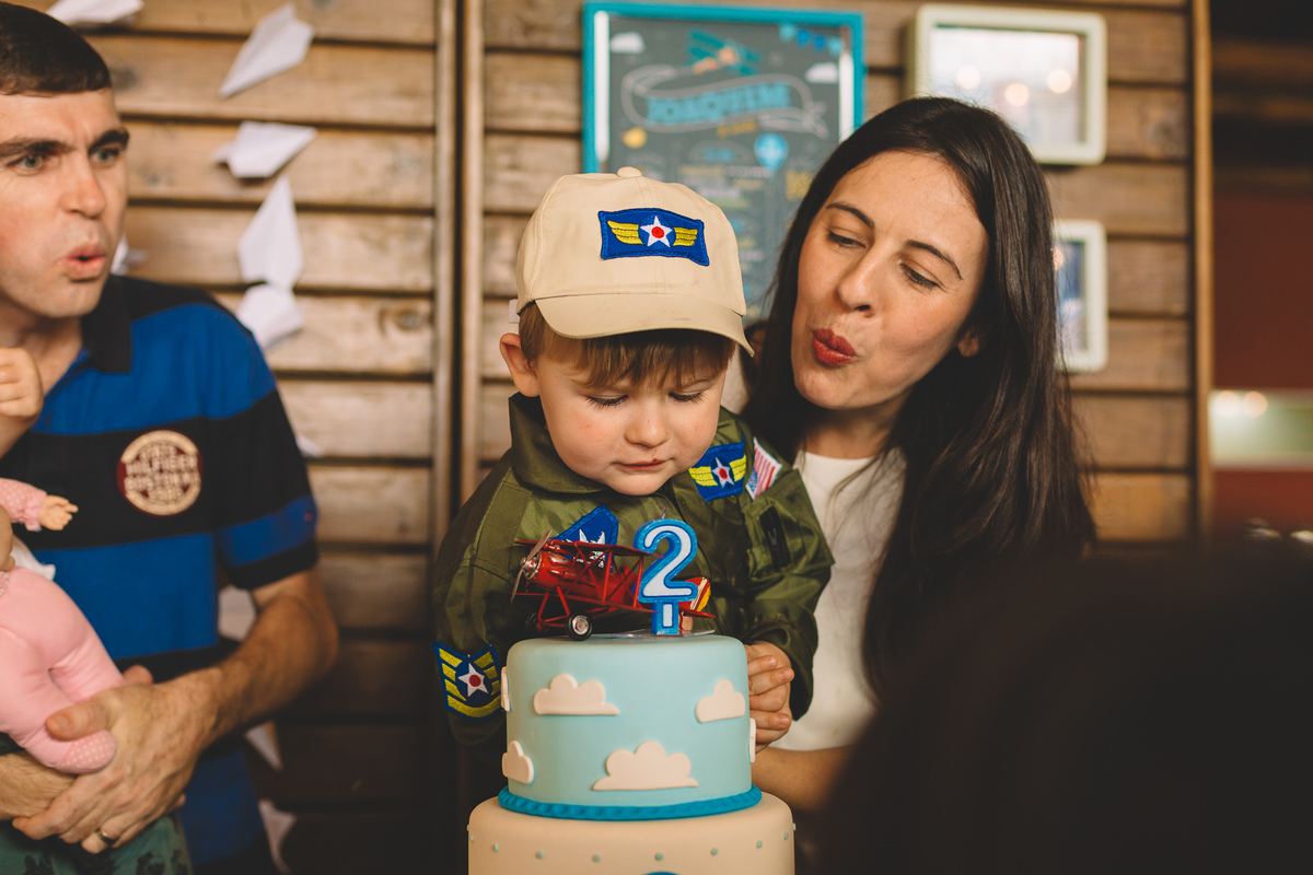 mãe soprando o bolo de aniversário do filho