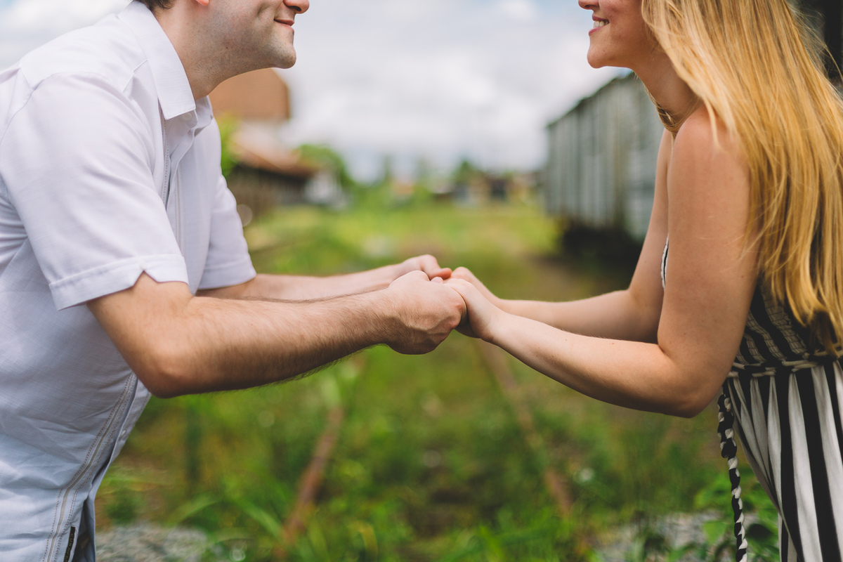 Casal de mãos dadas um de frente para o outro