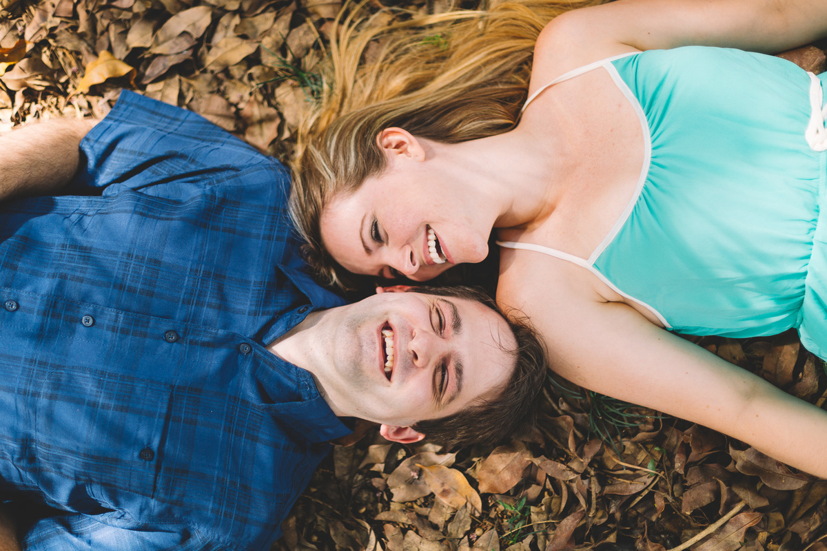 Casal deitado no chão gargalhando