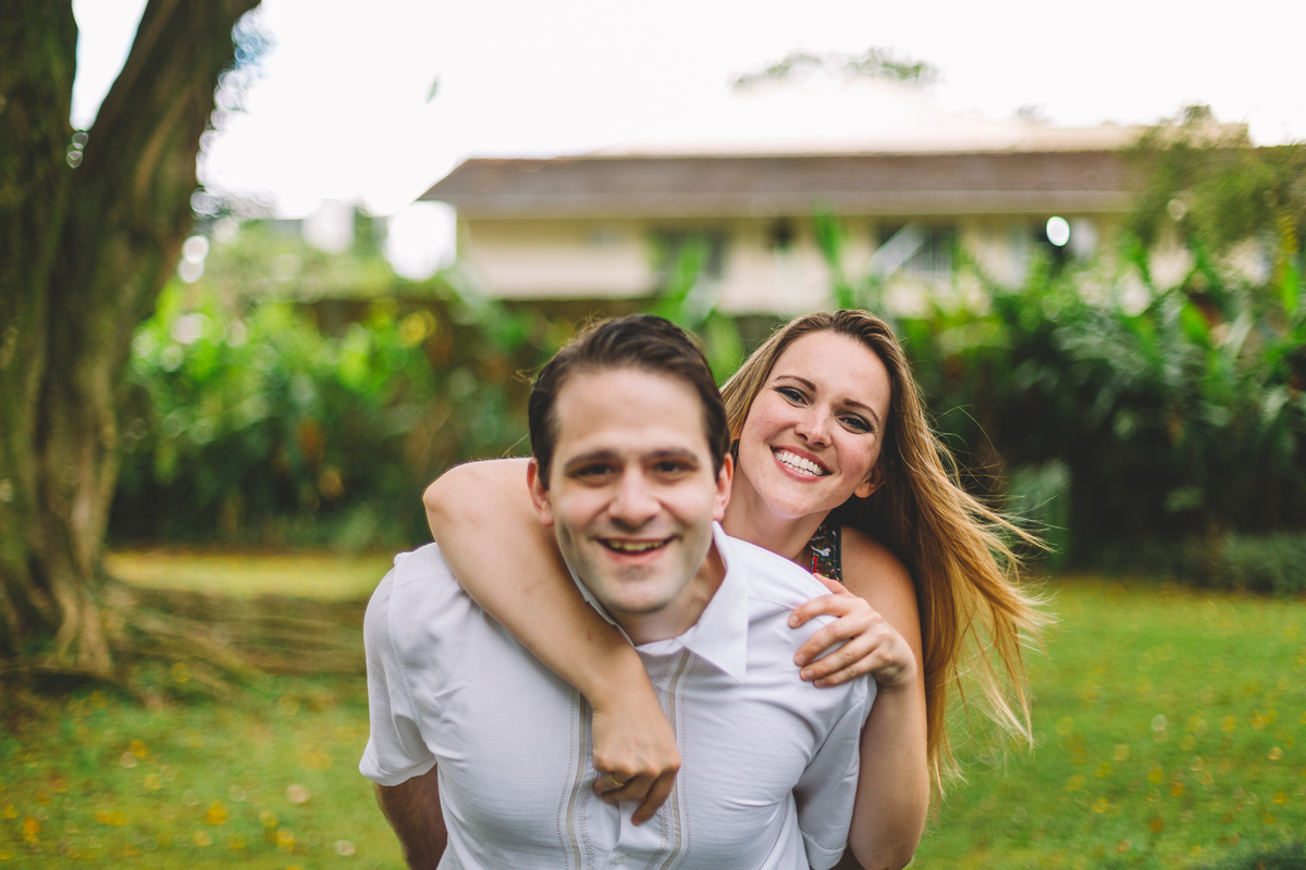 Noiva pulando nas costas do noivo e os dois estão sorrindo
