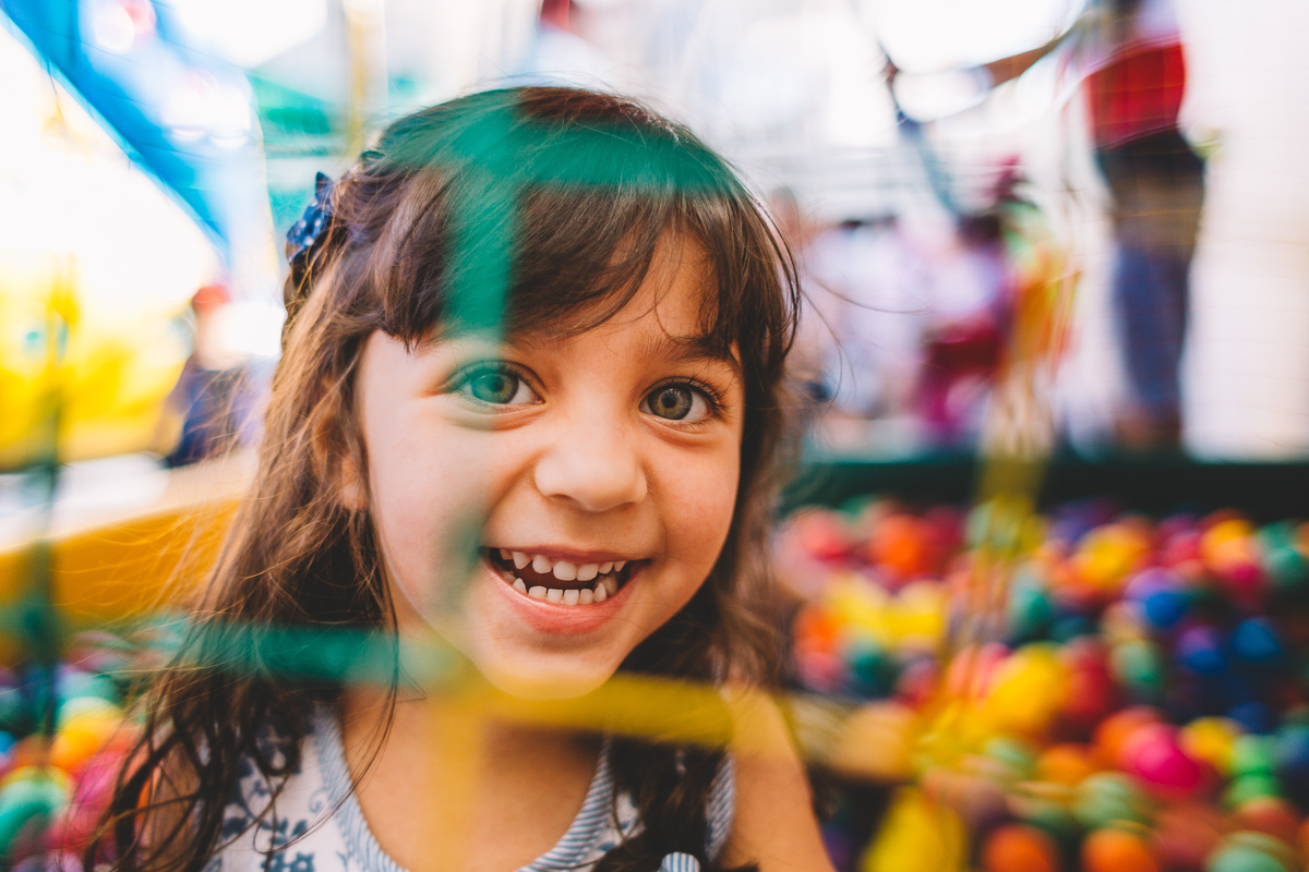Criança sorrindo dentro da piscina de bolinhas