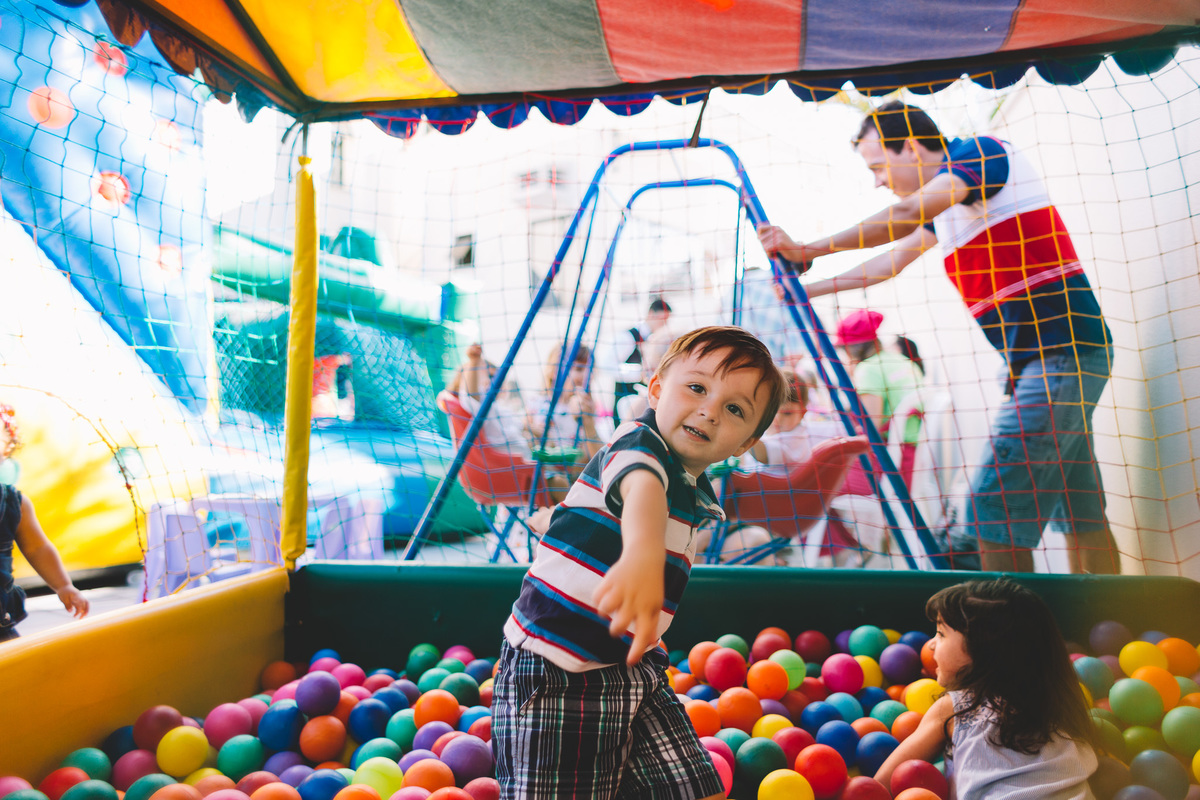 Menino brincando de jogar bolinhas na piscina de bolinha