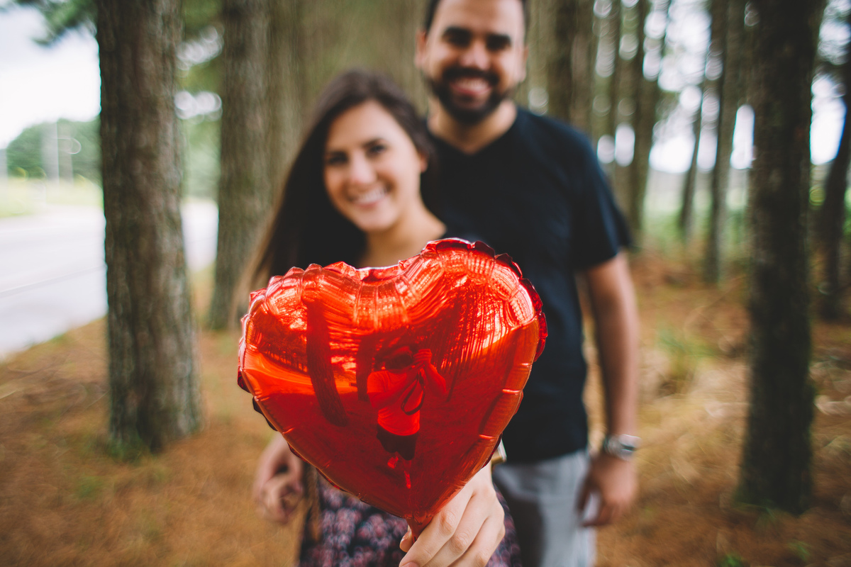 Fotógrafo aparecendo no reflexo do balão vermelho do casal