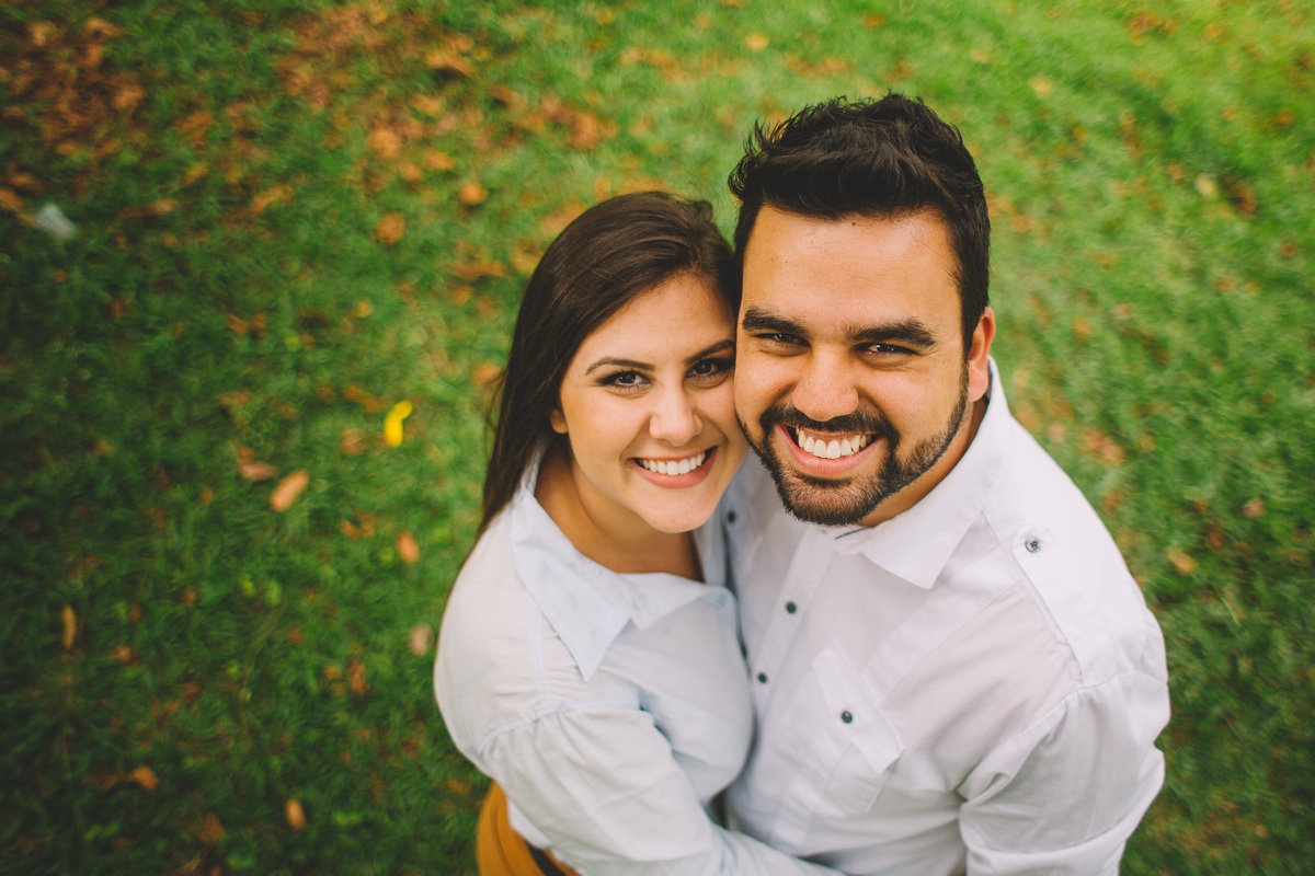 Casal sorrindo abraçados com. fundo de grama