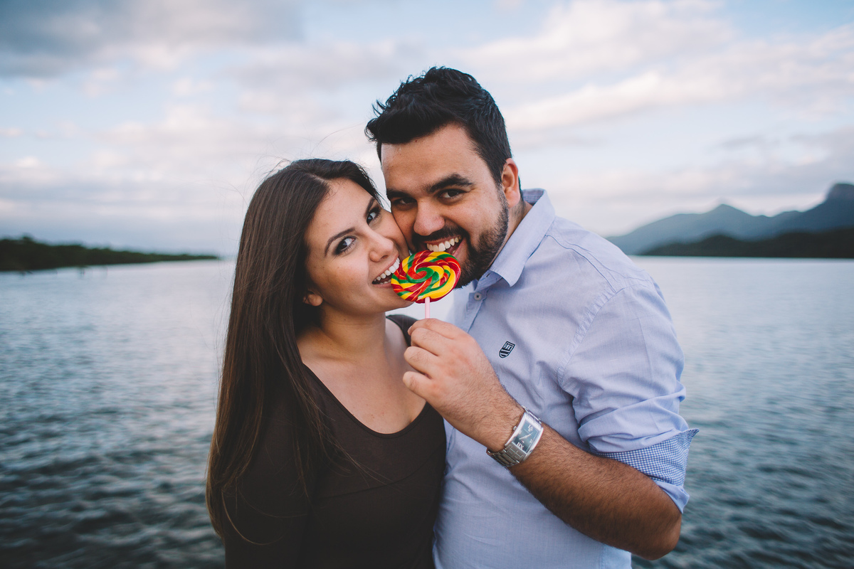 noivos mordendo o pirulito colorido enquanto sorriem