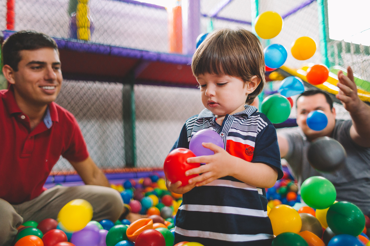 Convidados  brincando na piscina de bolinhas com a criança