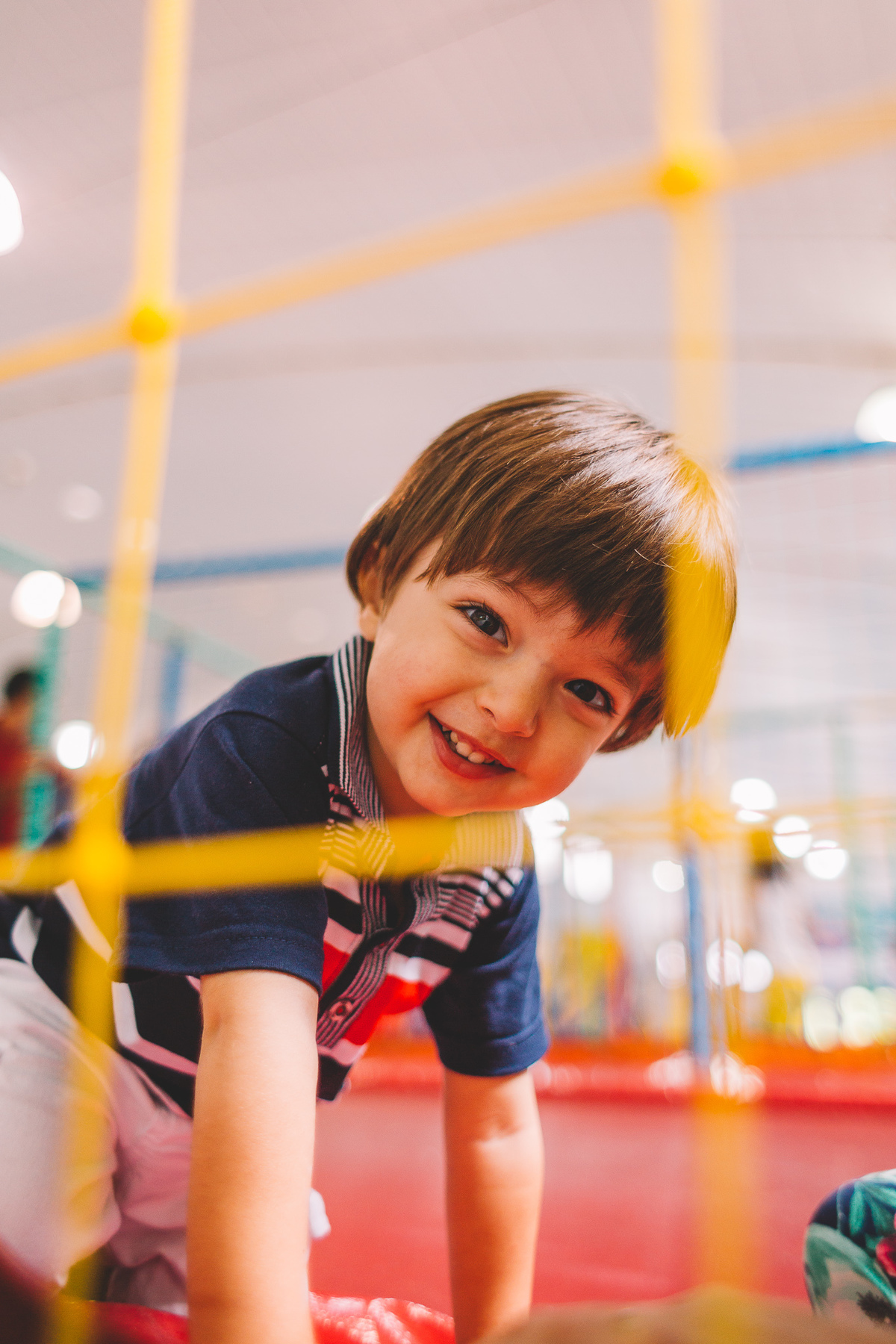 Criança sorrindo e brincando na cama elástica