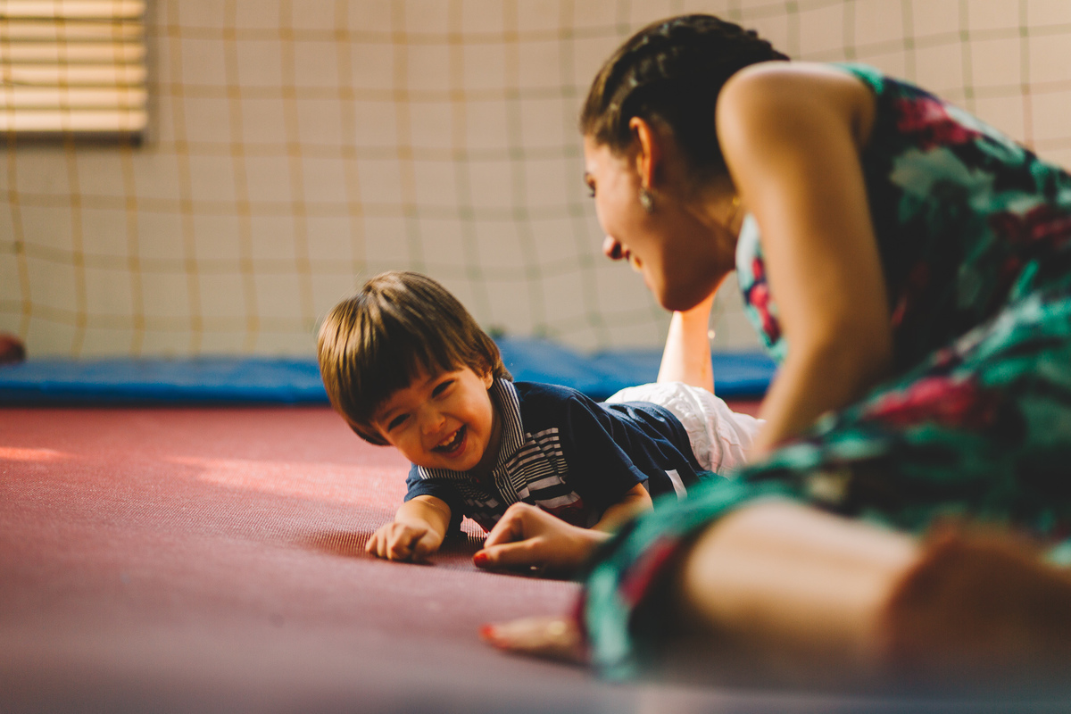 Filho e mãe brincando na cama elástica