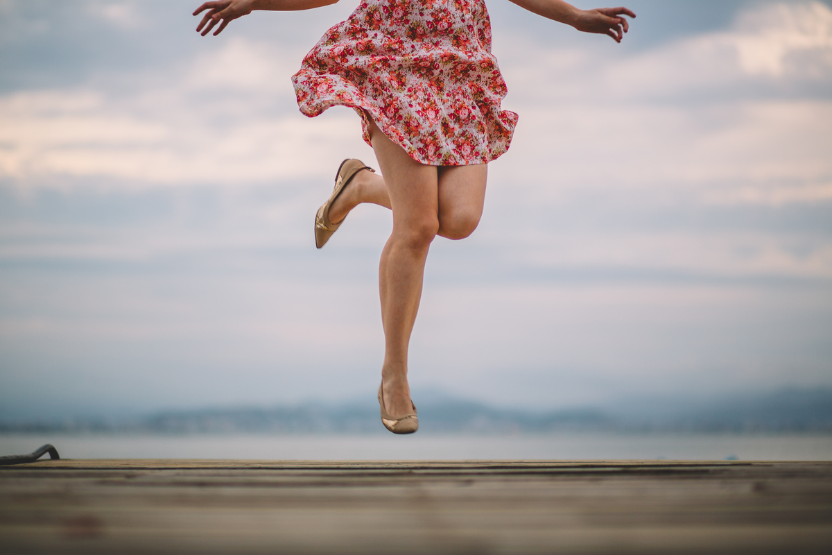 Moça de vestido saltando no ar