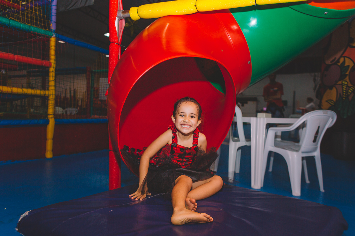 Criança sorrindo descendo no escorregador