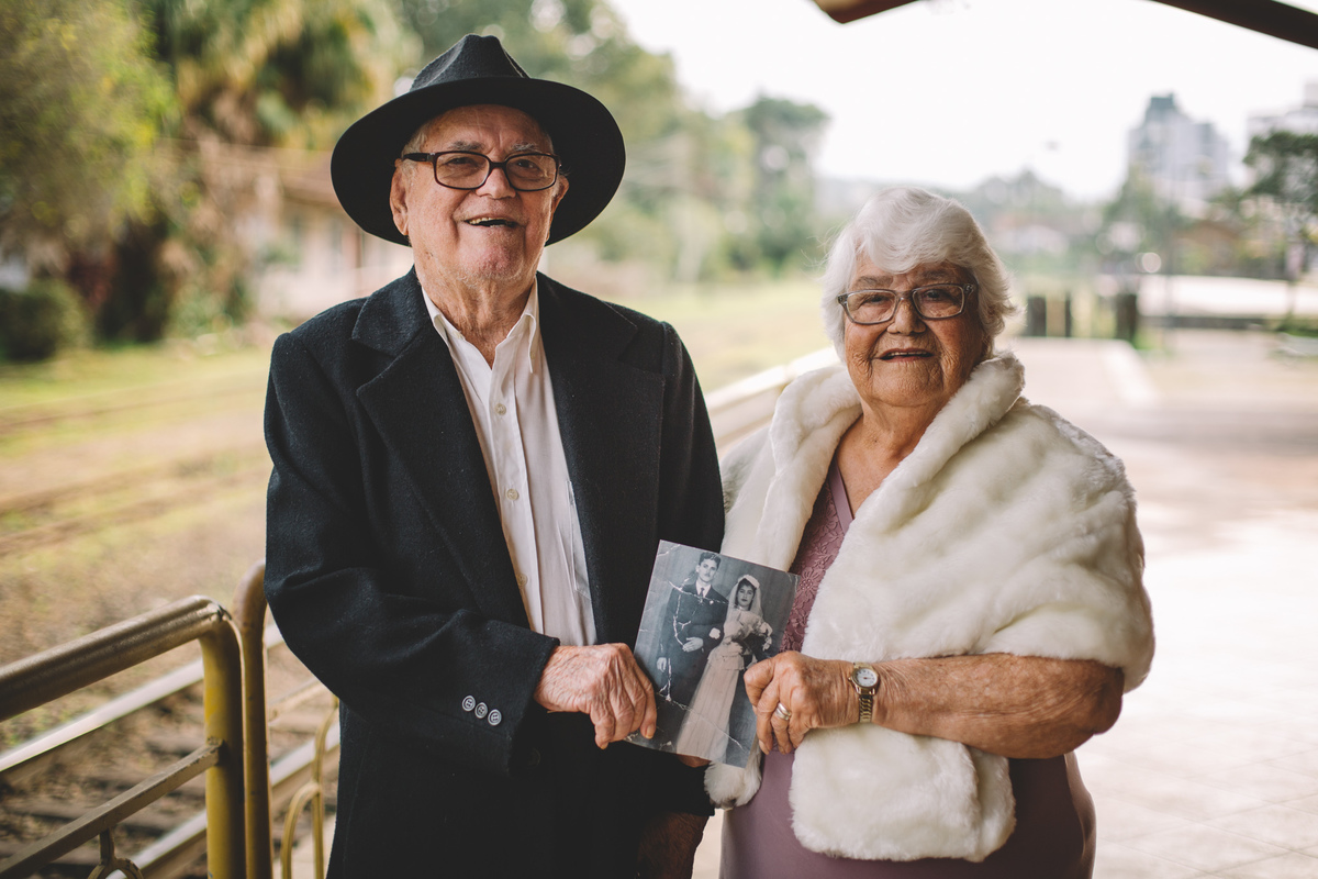 Casal de idosos segurando a foto antiga do casamento deles