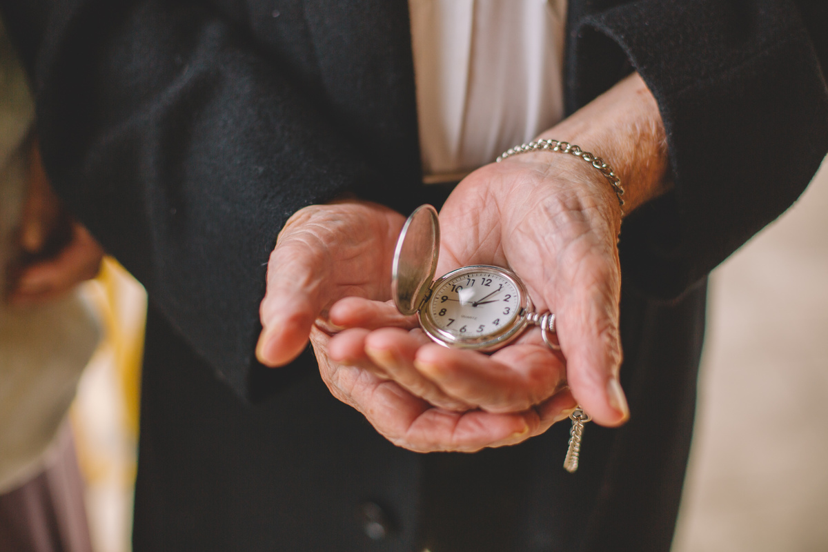 Foto do noivo segurando um relógio antigo