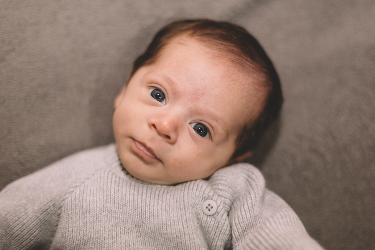 bebê sério olhando para cima com os olhos claros