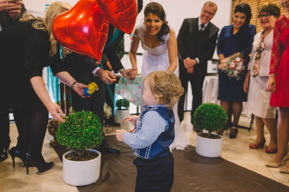 Criança fofa entrando com as alianças e balões vermelhos