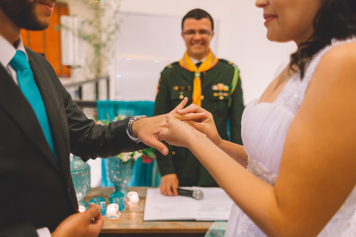 Noiva colocando a aliança no dedo do noivo