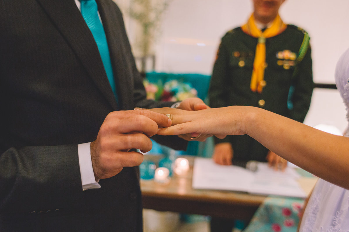 noivo colocando a aliança no dedo da noiva