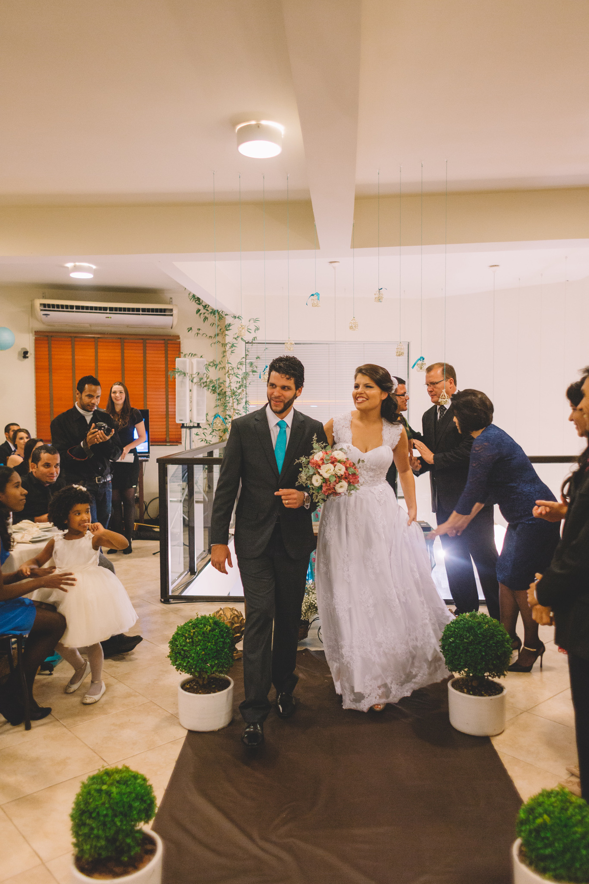 Casal saindo de braços dados felizes após o fim  da cerimônia de casamento