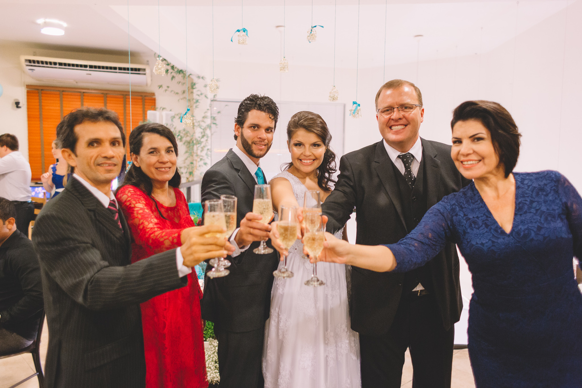 Familia do noivo e da noiva brindando o casamento com taças de champagne na mão