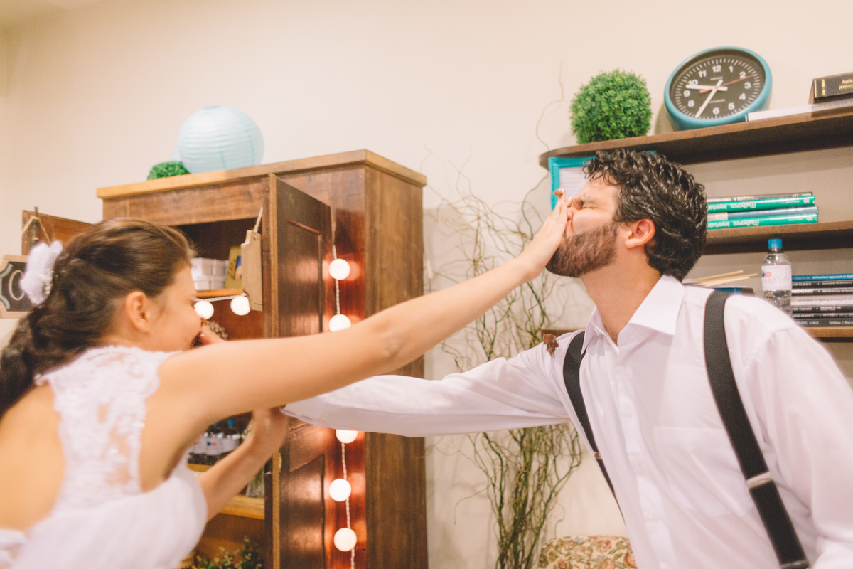 noivo e a noiva esfregando bolo um na cara do outro