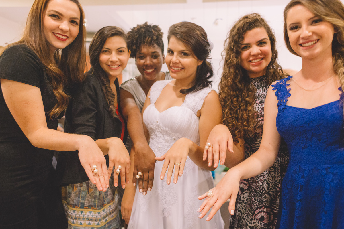 Noiva e suas amigas mostrando suas aliança