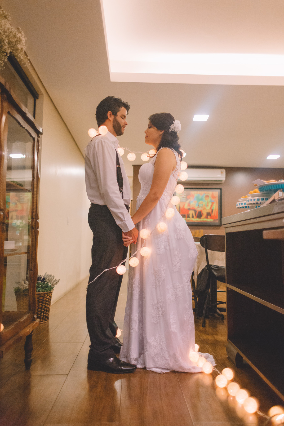 casal enrolado no enfeite de luzes do casamento