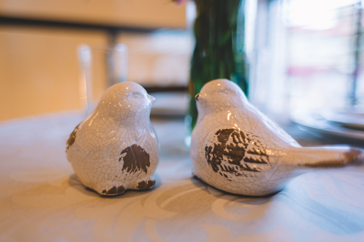 Enfeites de passarinhos de porcelana  em cima da mesa