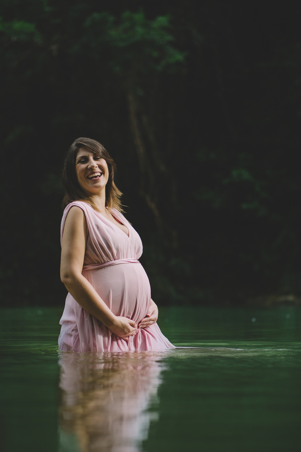 Grávida sorrindo dentro do rio