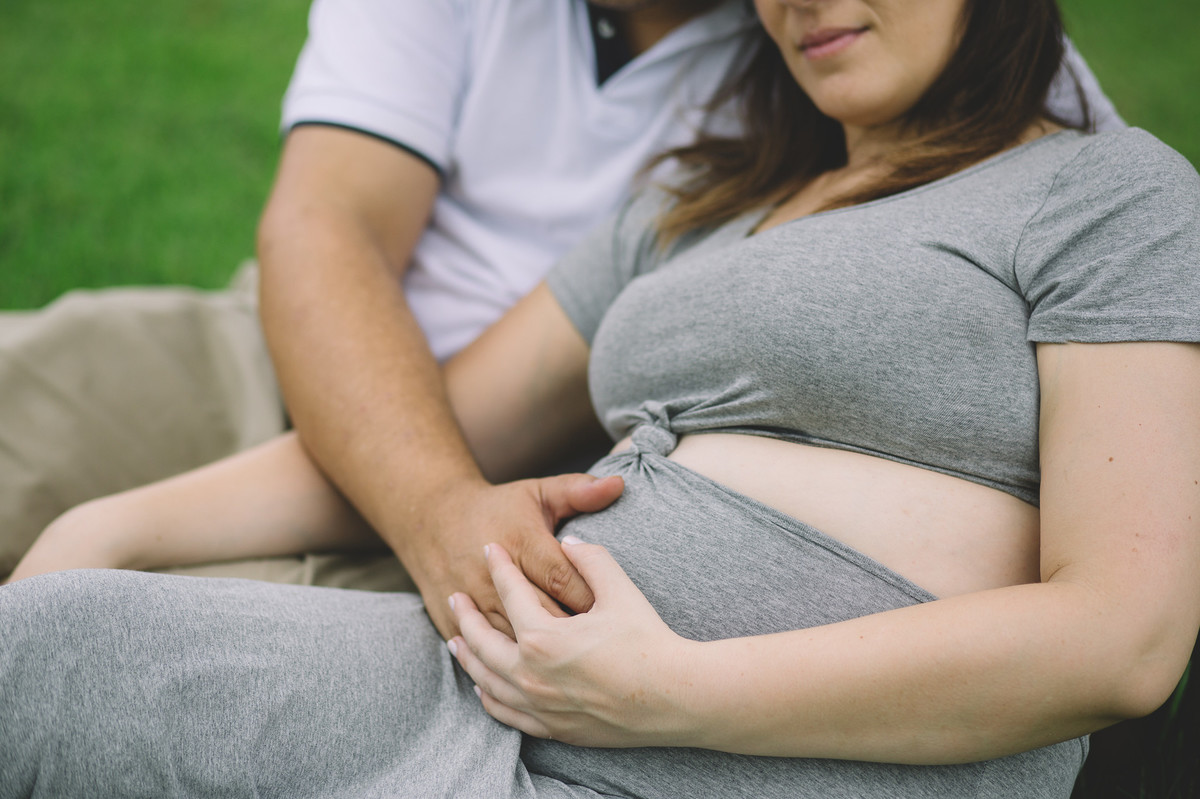 Grávida e marido acariciando a barriga