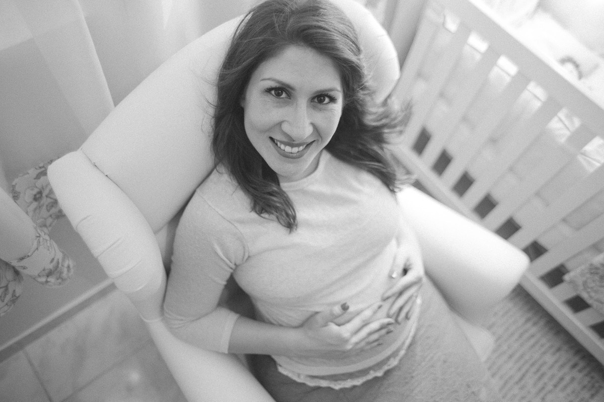 Grávida feliz dentro do quarto do bebê