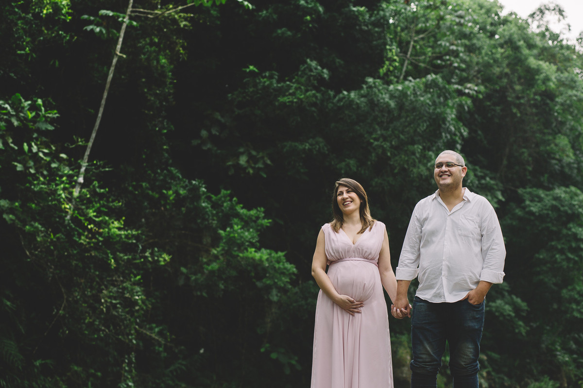 Gestante de mãos dadas com o marido sorrindo